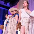 Des mannequins subrun podium, vêtus de blanc. Ils défilent pour le projet de fin d'année des étudiants de la la Ryerson School of Fashion