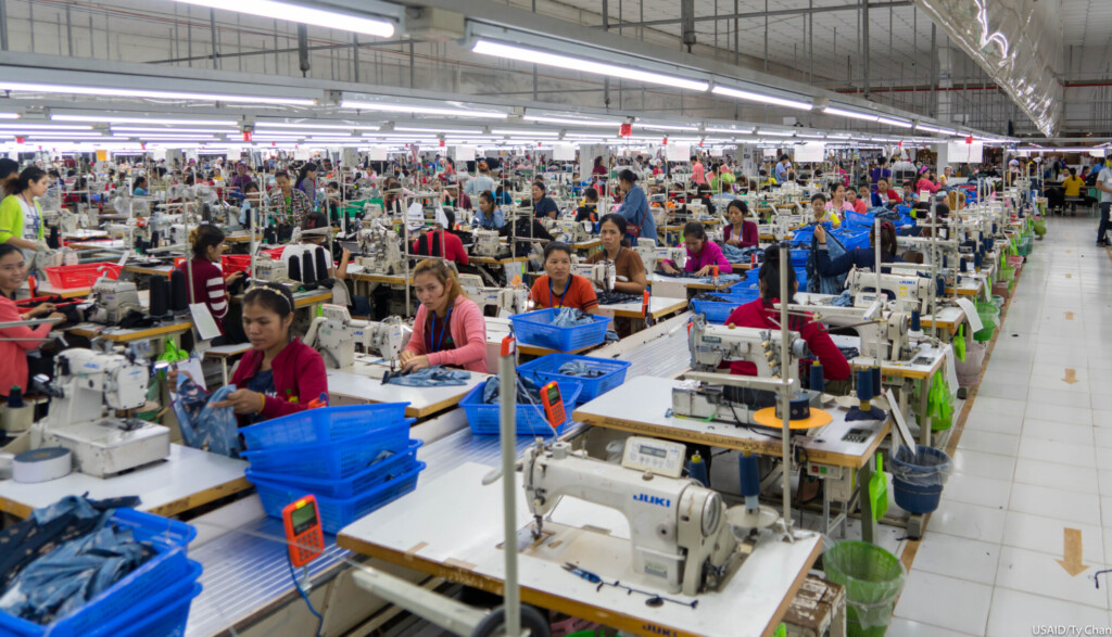 Des ouvriers et ouvrieres travaillent sur des machines à coudre dans une usine textile au Cambodge. 