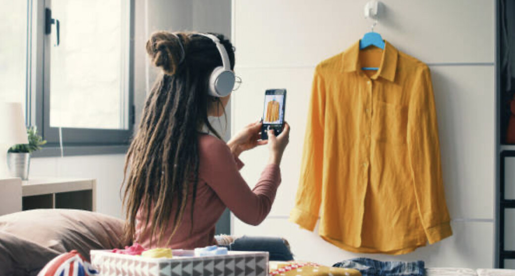 Une femme en train de prendre en photo une chemise qu'elle souhaite vendre